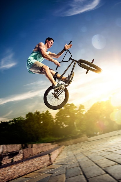 Ciclista de bmx engañando en las colinas del bosque