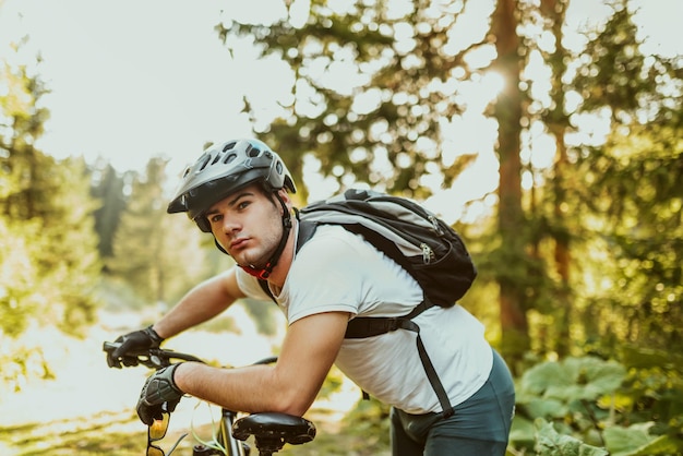 Ciclista cansado con ropa deportiva y casco tomando un descanso después de entrenar al aire libre Hombre caucásico saludable que pasa tiempo libre para hacer ejercicio al aire libre