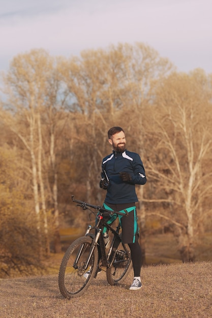 Ciclista cavalga pela floresta de outono e parque