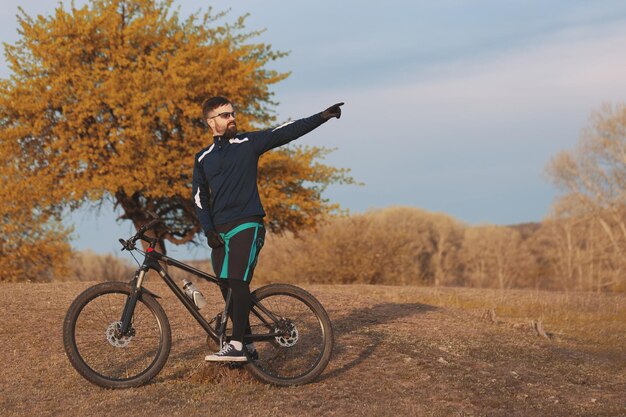 Ciclista cavalga pela floresta de outono e parque