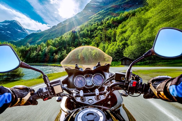 Foto ciclista conduciendo una motocicleta paseos a lo largo de la carretera asfaltada. vista en primera persona.