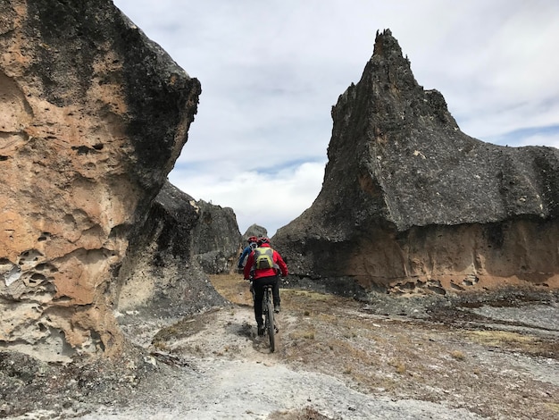 Ciclista conduzindo entre rocas gigantes