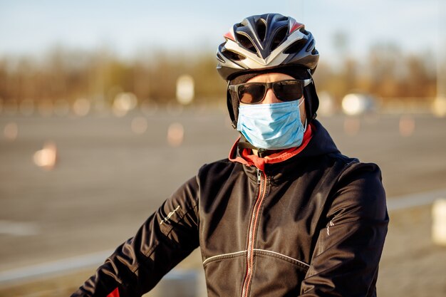 Ciclista durante la cuarentena con casco y máscara