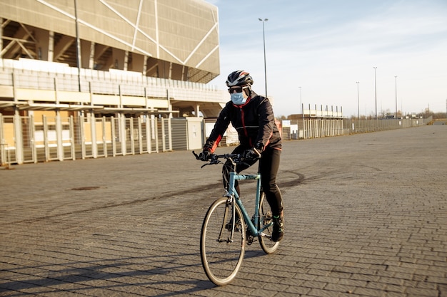 Ciclista durante la cuarentena monta una bicicleta con una máscara