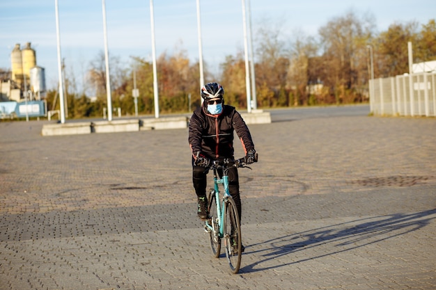 Ciclista durante la cuarentena monta una bicicleta con una máscara