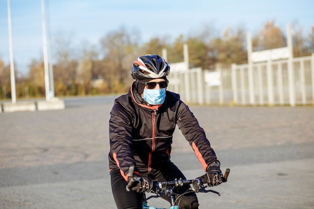 Ciclista durante la cuarentena monta una bicicleta con una máscara