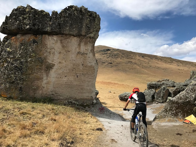 ciclista cuesta abajo por un camino llano entre rocas