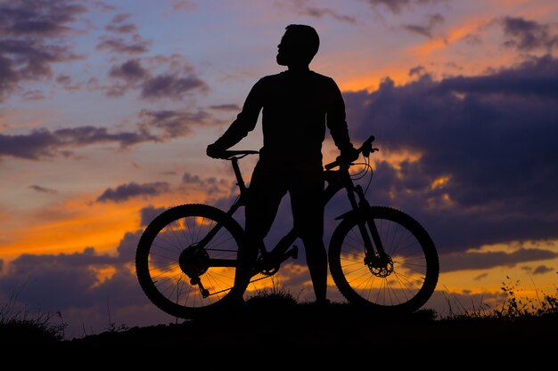 Ciclista de bermuda e malha em uma bicicleta moderna de carbono com suspensão a ar