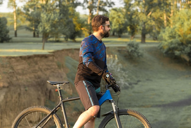 Ciclista de calça e jaqueta de lã em uma bicicleta moderna com suspensão pneumática viaja off-road