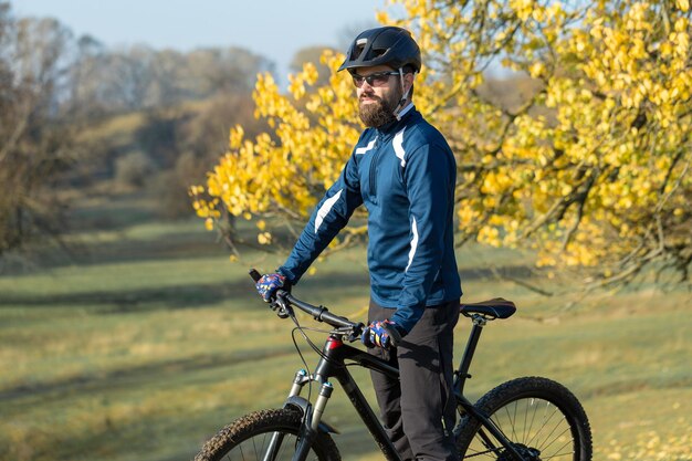 Ciclista de calça e jaqueta de lã em uma bike hardtail moderna de carbono com um garfo com suspensão a ar