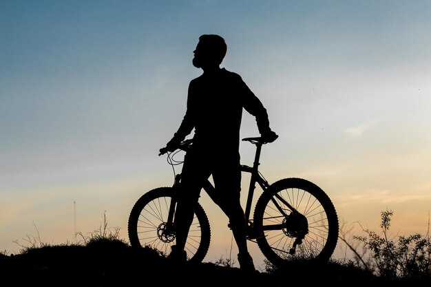 Ciclista de calça e jaqueta de lã em uma bike hardtail moderna de carbono com um garfo com suspensão a ar