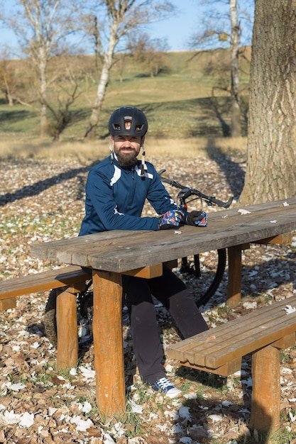 Ciclista de calça e jaqueta de lã em uma moderna bicicleta rígida de carbono com suspensão a ar.