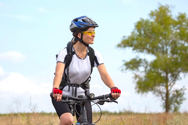 Ciclista de mulher bonita anda no campo de bicicleta. Estilo de vida saudável e esporte. Lazer e hobbies