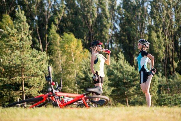 Ciclista de mulheres fazendo exercícios depois de andar de bicicleta ao ar livre no parque