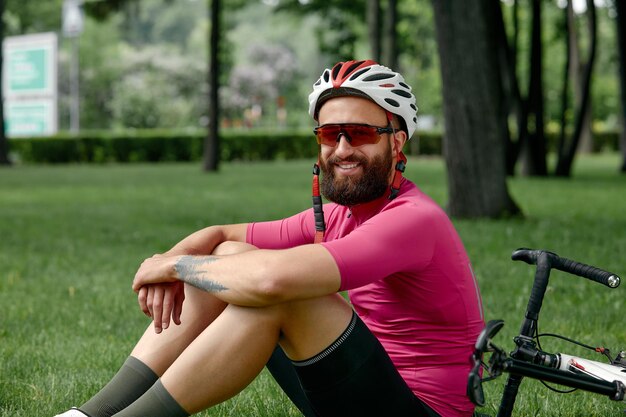 Ciclista descansando en los verdes pastos Verano buen humor