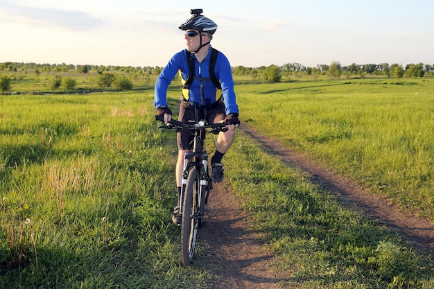 Ciclista em bicicleta pelos campos de trigo