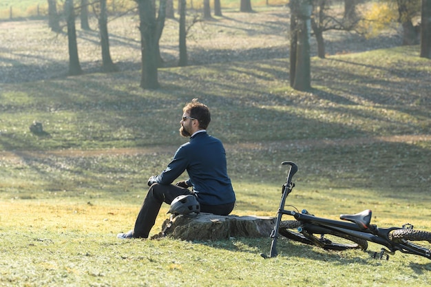 Ciclista em calças e jaqueta de lã em uma moderna bicicleta hardtail de carbono com um garfo de suspensão a ar passeios offroad