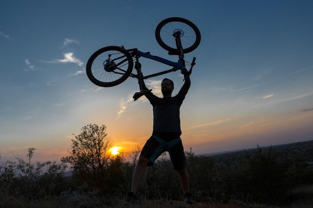 Ciclista em calças e jaqueta de lã em uma moderna bicicleta hardtail de carbono com um garfo de suspensão a ar