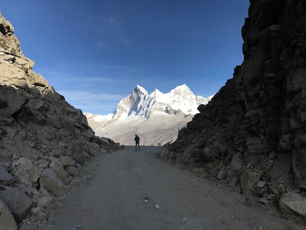 Ciclista entre dos montanas debajo del nevado