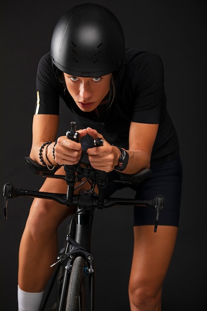 Foto ciclista femenina posando con bicicleta y casco