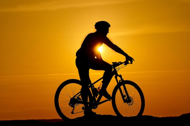 Ciclista en el fondo del deporte al atardecer y el concepto de viaje