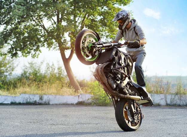 ciclista haciendo trucos extremos en motocicleta deportiva en verano.