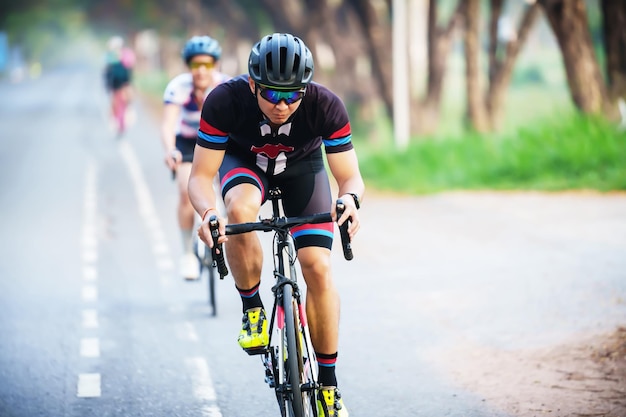 Foto ciclista lidera em açãovista frontal homem andando de bicicleta na estrada de corrida