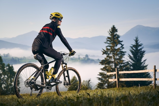 Ciclista masculina andando de bicicleta nas montanhas