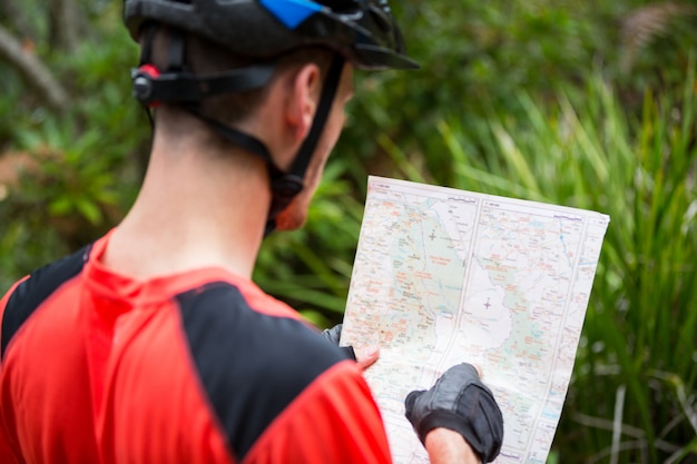 Ciclista masculina, olhando para o mapa