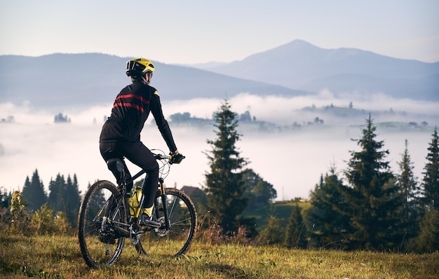 Ciclista masculino montando bicicleta en las montañas