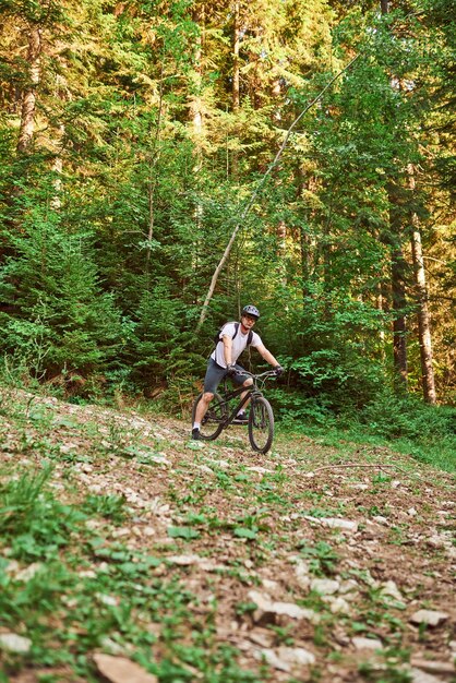 Un ciclista monta una bicicleta en caminos forestales extremos y peligrosos Enfoque selectivo