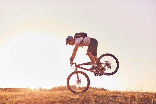 Un ciclista montando en bicicleta en una montaña al atardecer