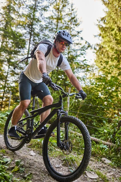 Ciclista montando en bicicleta por el sendero del bosque. Hombre en bicicleta por pista de enduro. Deporte fitness motivación e inspiración. Concepto de deporte extremo. Enfoque selectivo. foto de alta calidad