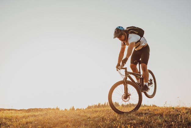 Ciclista montando la bicicleta en el sendero en el bosque Hombre en bicicleta en la pista de enduro Motivación e inspiración para el fitness deportivo Concepto de deporte extremo Enfoque selectivo Foto de alta calidad