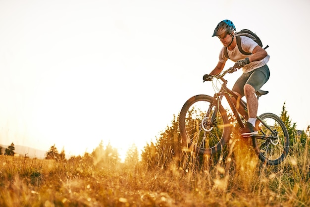 Ciclista montando la bicicleta en el sendero en el bosque Hombre en bicicleta en pista de enduro Motivación e inspiración para el fitness deportivo Concepto de deporte extremo Enfoque selectivo