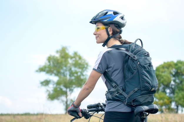 Ciclista de mujer hermosa y feliz con una bicicleta en la naturaleza. Estilo de vida saludable y deportes. Ocio y aficiones