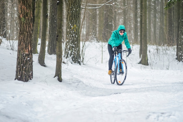 Ciclista na floresta de neve