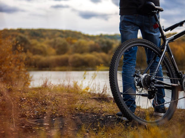 Ciclista en la orilla del río. Estilo de vida de otoño