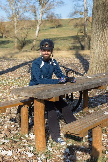 Ciclista en pantalones y chaqueta polar en una bicicleta rígida con una horquilla de suspensión neumática paseos offroad