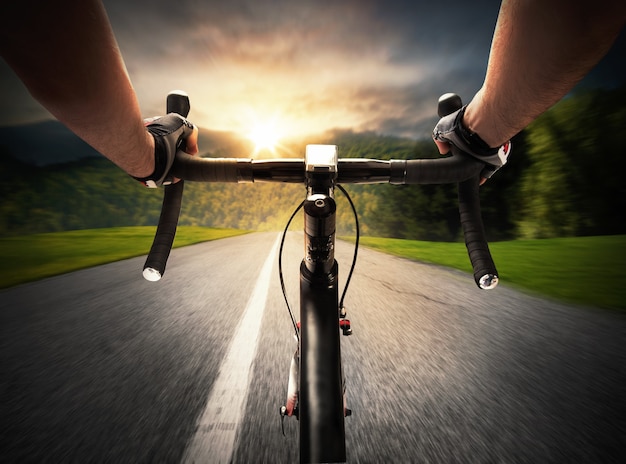 Foto ciclista pedalando em uma rua à luz do dia