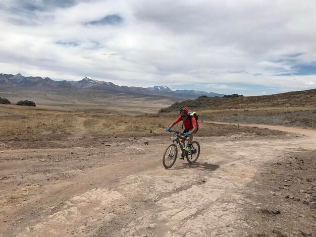 Ciclista por la ancha llanura por um caminho escabroso