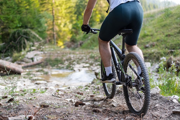 Ciclista profesional de bicicleta de montaña recorriendo un sendero sobre el agua en el bosque Deporte de aventura extremo