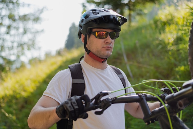 Ciclista profissional de mountain bike montando uma trilha na floresta esporte de aventura extrema ao ar livre