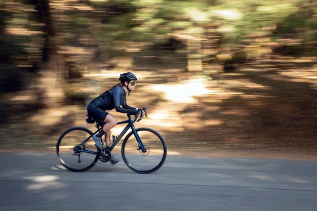 Ciclista profissional em alta velocidade na estrada com seu conceito de triatlo de bicicleta de trilha