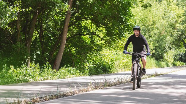 Ciclista profissional focado andando pela estrada do parque