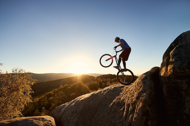 Ciclista profissional se equilibrando em uma bicicleta experimental ao pôr do sol