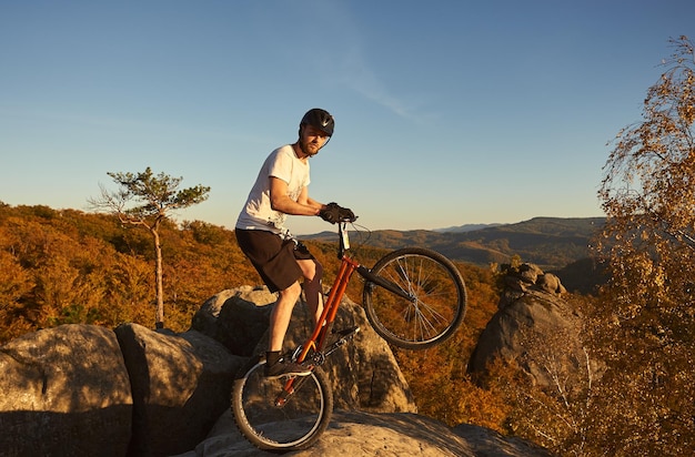 Ciclista profissional se equilibrando em uma bicicleta experimental ao pôr do sol