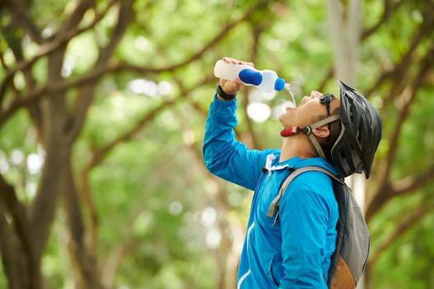 Ciclista sediento bebiendo agua dulce