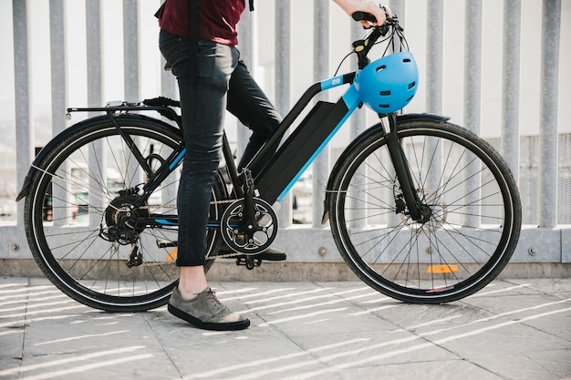 Ciclista urbana, tendo um freio na e-bicicleta