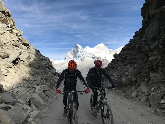 Ciclistas cruzando entre duas montanhas